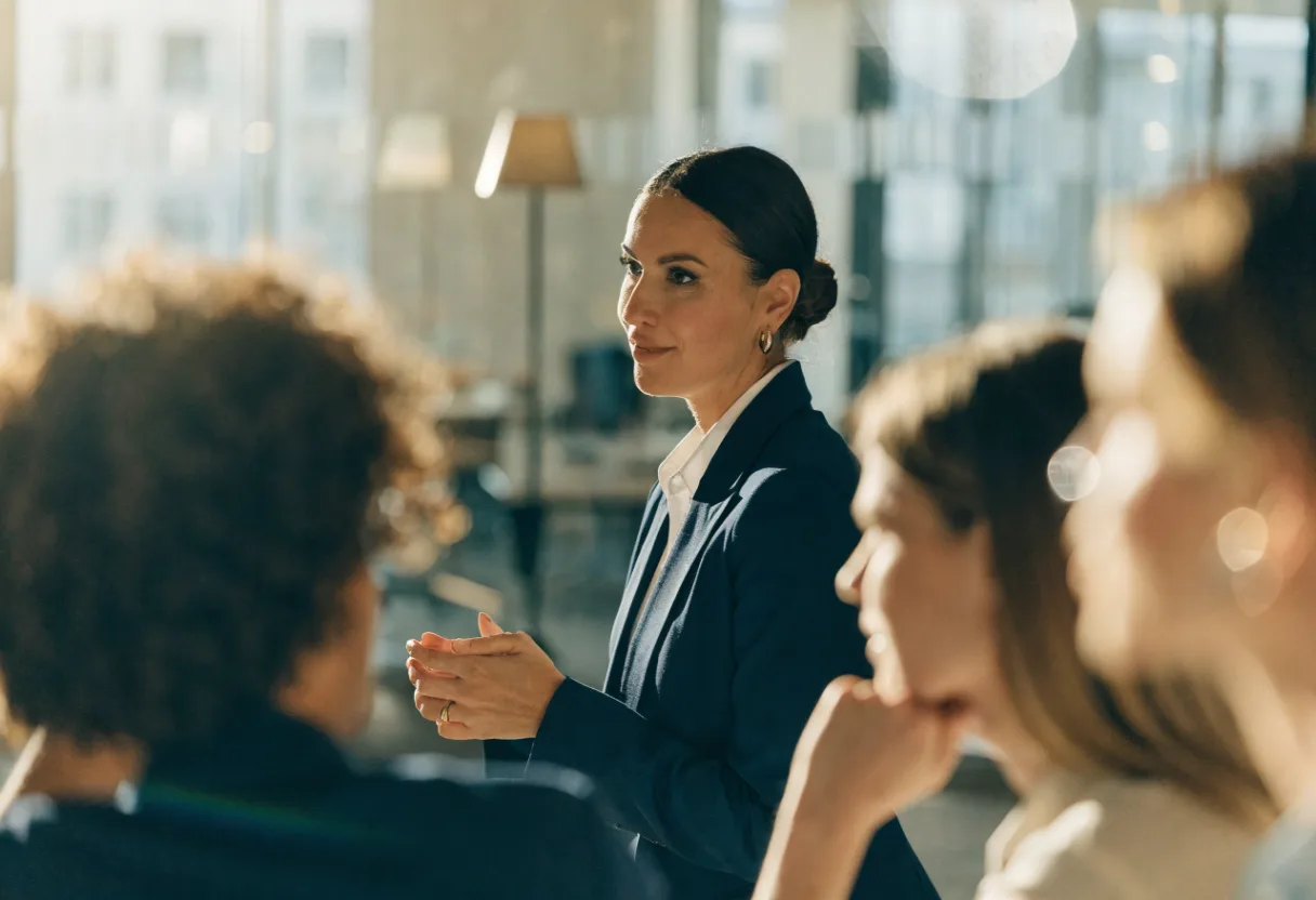 Geschäftsfrau als Finance-Managerin spricht ruhig mit einem engagierten Team im hellen Büro